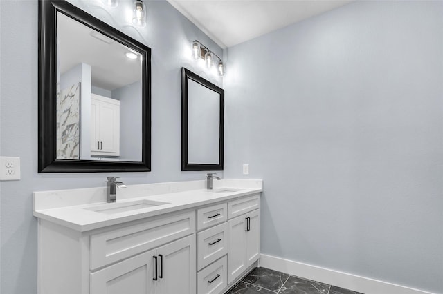 bathroom with marble finish floor, a sink, baseboards, and double vanity