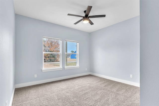 spare room featuring ceiling fan, carpet, and baseboards