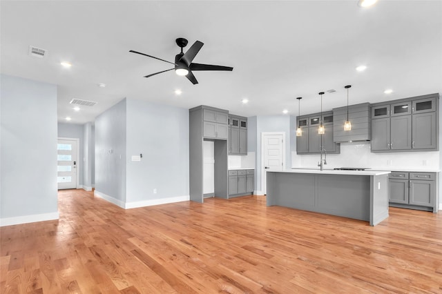 kitchen with light countertops, light wood finished floors, gray cabinets, and visible vents