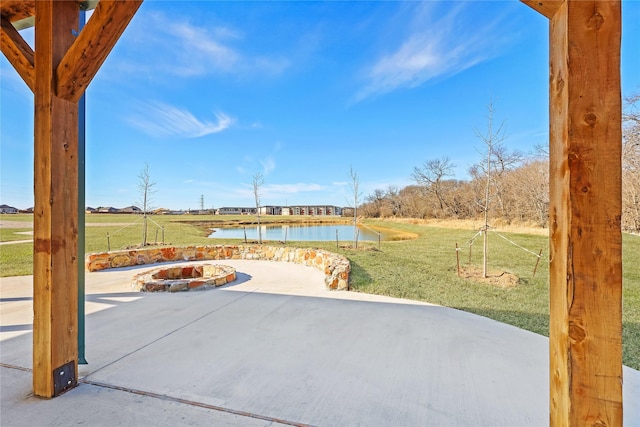 view of patio with a water view and an outdoor fire pit