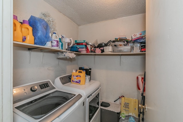 laundry room featuring a textured ceiling and washer and clothes dryer