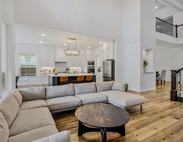 living room with a towering ceiling and light hardwood / wood-style floors