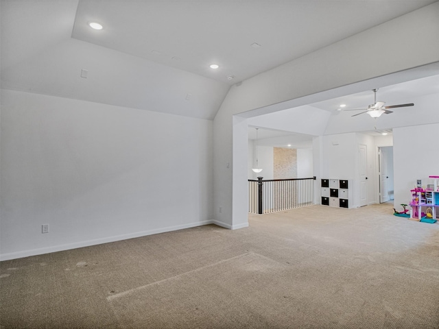 interior space with ceiling fan, light colored carpet, and lofted ceiling