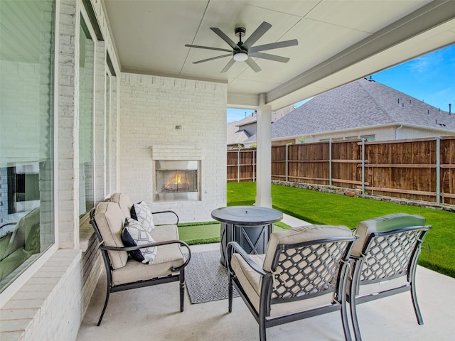 view of patio featuring ceiling fan and an outdoor brick fireplace