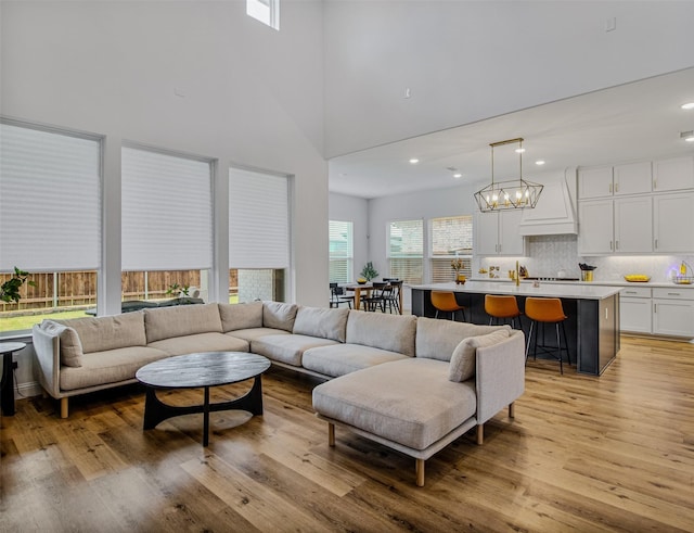 living room featuring light hardwood / wood-style flooring and a towering ceiling