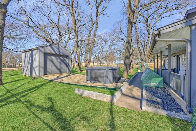 view of yard featuring driveway, a detached garage, and an outbuilding