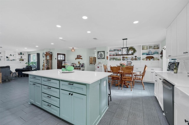 kitchen featuring white cabinets, dishwasher, a kitchen island, light countertops, and recessed lighting