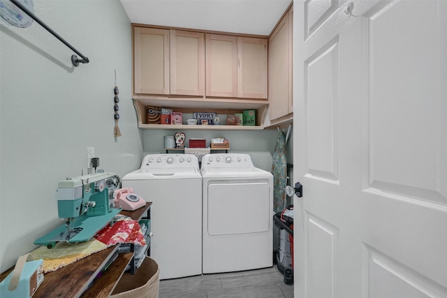 laundry area with washing machine and dryer, cabinet space, and light wood-style flooring