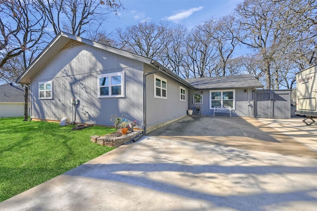 view of front of property featuring driveway, a gate, and a front yard