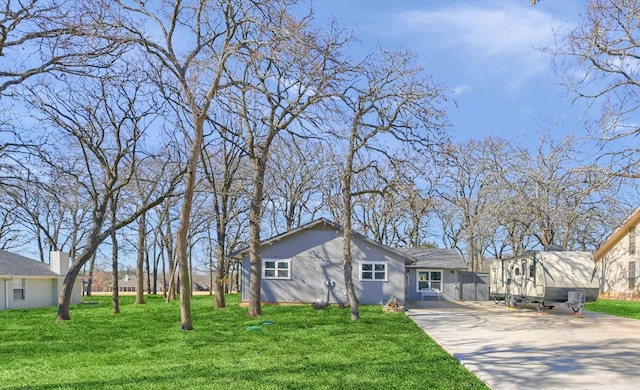 view of front of property featuring concrete driveway and a front lawn