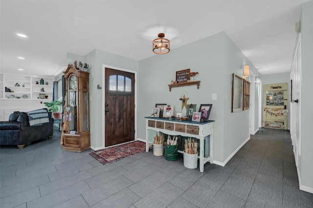 foyer entrance with baseboards and recessed lighting