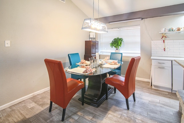 dining area with light hardwood / wood-style flooring and vaulted ceiling