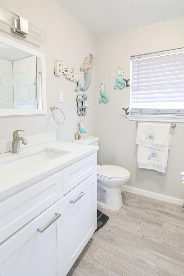 bathroom with hardwood / wood-style floors, toilet, and vanity