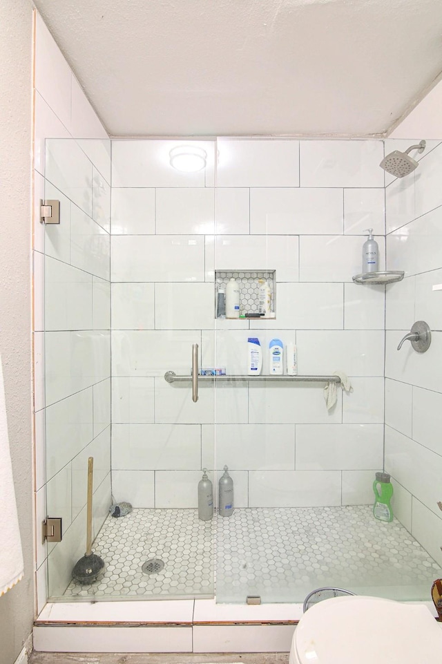 bathroom featuring toilet and an enclosed shower