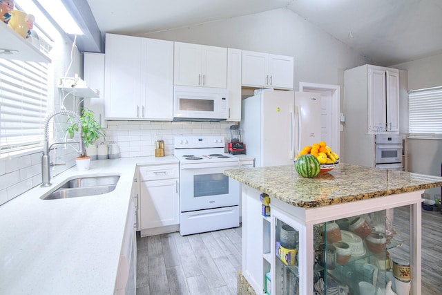 kitchen with white cabinets, backsplash, and white appliances