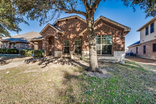 view of front of house with a front yard and central AC unit