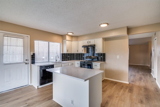 kitchen featuring sink, white cabinets, black appliances, and light wood-type flooring