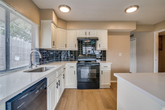 kitchen with black appliances, white cabinetry, light hardwood / wood-style flooring, and sink