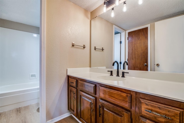 bathroom featuring hardwood / wood-style floors, vanity, and a textured ceiling