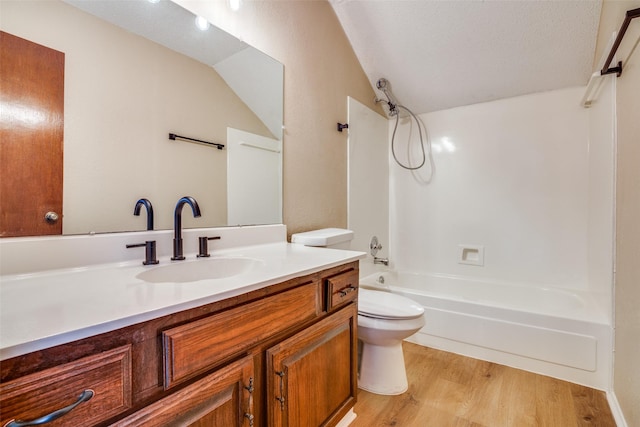 full bathroom with a textured ceiling, wood-type flooring, vanity, toilet, and  shower combination