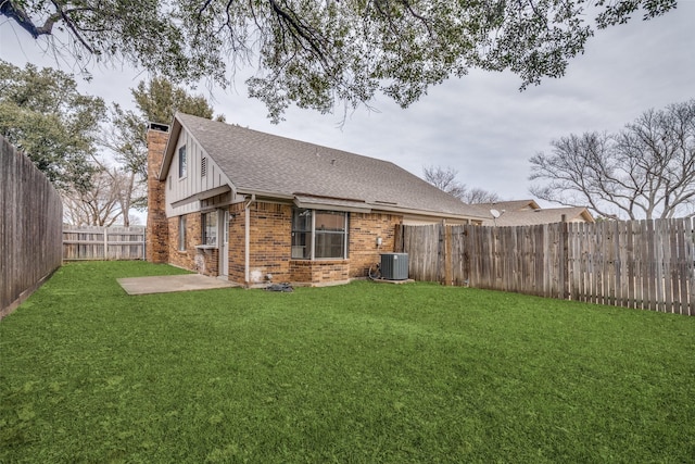 rear view of property featuring a patio area, a yard, and central AC