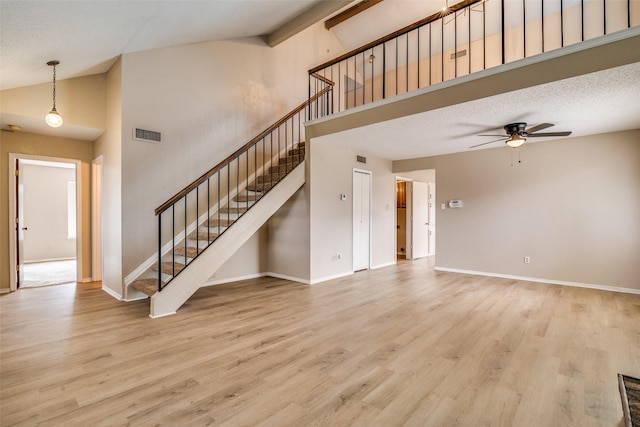 unfurnished living room with a textured ceiling, light hardwood / wood-style flooring, high vaulted ceiling, and ceiling fan