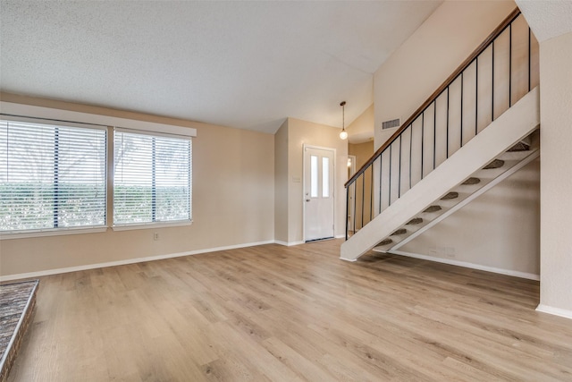 unfurnished living room with light hardwood / wood-style flooring and vaulted ceiling