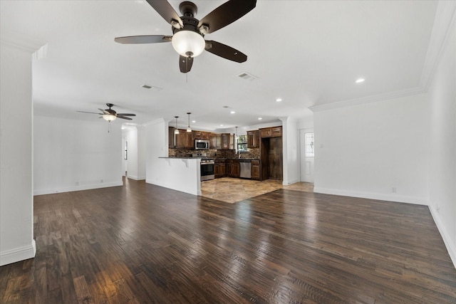 unfurnished living room with ceiling fan, crown molding, and dark hardwood / wood-style floors