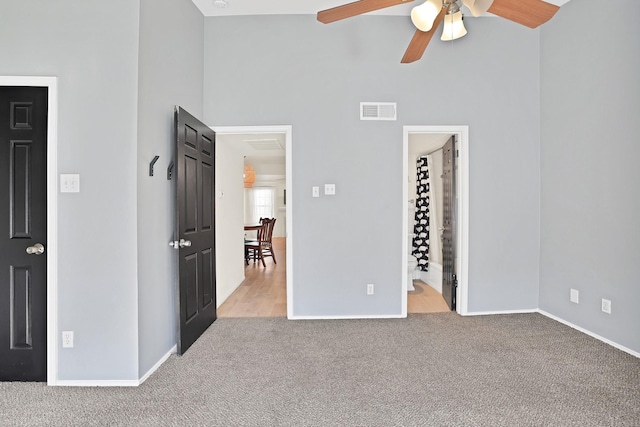 unfurnished bedroom with ceiling fan, light carpet, and ensuite bath