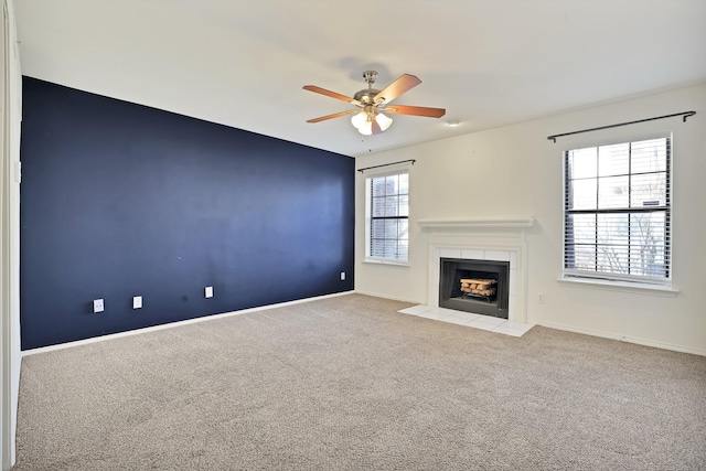 unfurnished living room featuring ceiling fan, light carpet, and a tiled fireplace