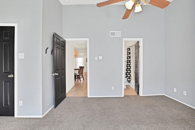 unfurnished living room with ceiling fan, light carpet, and a tile fireplace