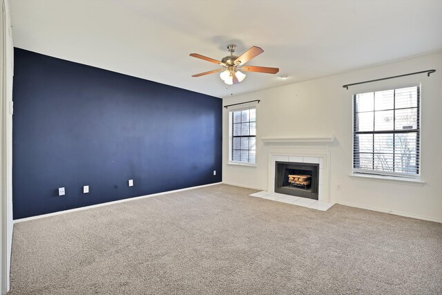 unfurnished living room with ceiling fan and carpet