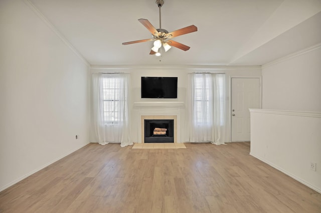 unfurnished living room with light hardwood / wood-style floors, lofted ceiling, ceiling fan, and a fireplace