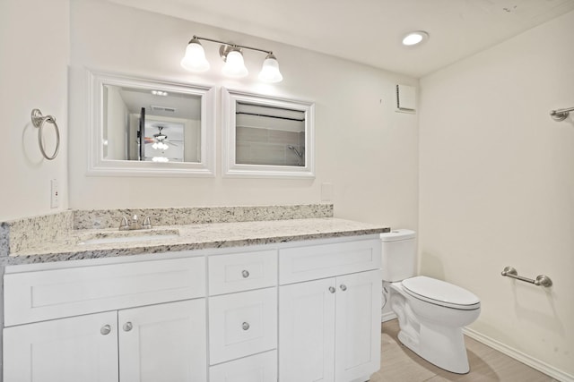 bathroom featuring wood-type flooring, toilet, and vanity