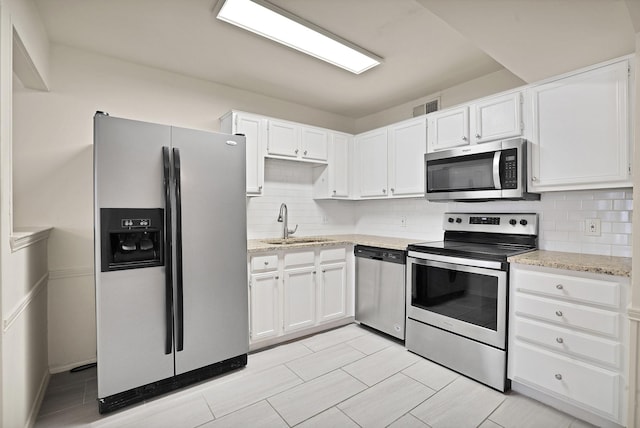 kitchen featuring white cabinets, stainless steel appliances, backsplash, and sink