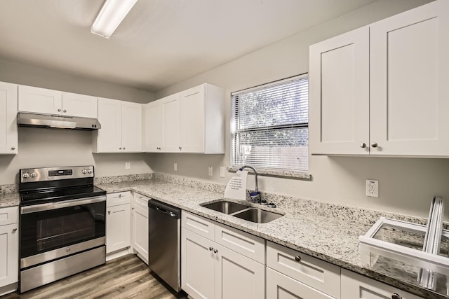 kitchen with sink, stainless steel appliances, white cabinets, and wood-type flooring