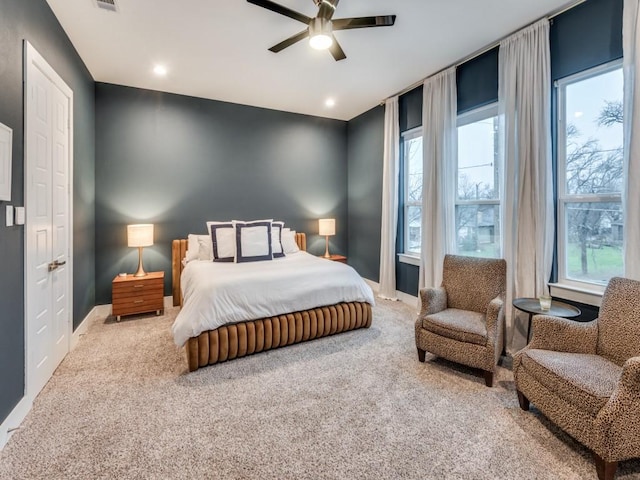 carpeted bedroom featuring ceiling fan and multiple windows