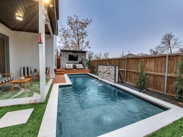 view of swimming pool with outdoor lounge area, a wooden deck, and pool water feature