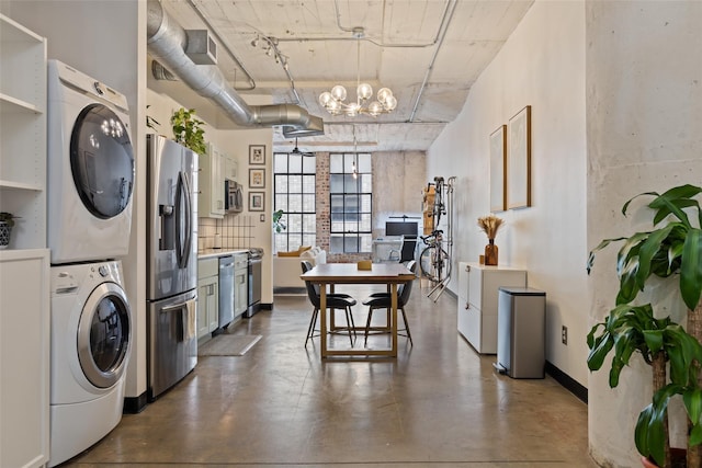 interior space with stacked washer / drying machine and a chandelier