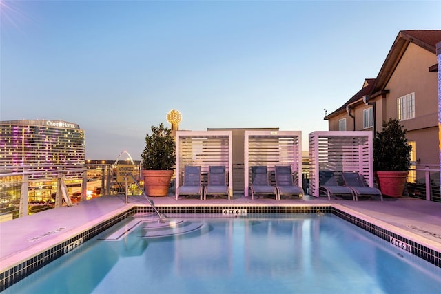 pool at dusk with a patio area