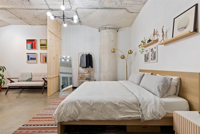 bedroom featuring ornate columns and concrete flooring