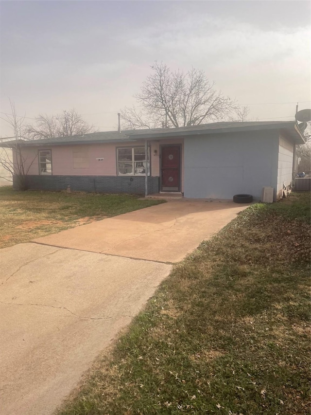 ranch-style home with a garage and a front yard