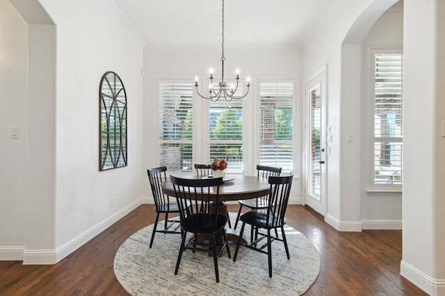 dining room featuring dark wood-type flooring, crown molding, and a chandelier