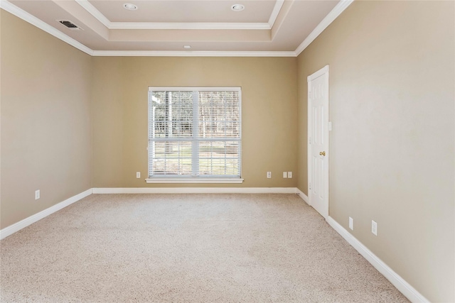 carpeted empty room featuring a tray ceiling and ornamental molding