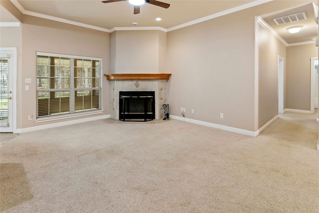 unfurnished living room featuring a tiled fireplace, light colored carpet, ceiling fan, and ornamental molding