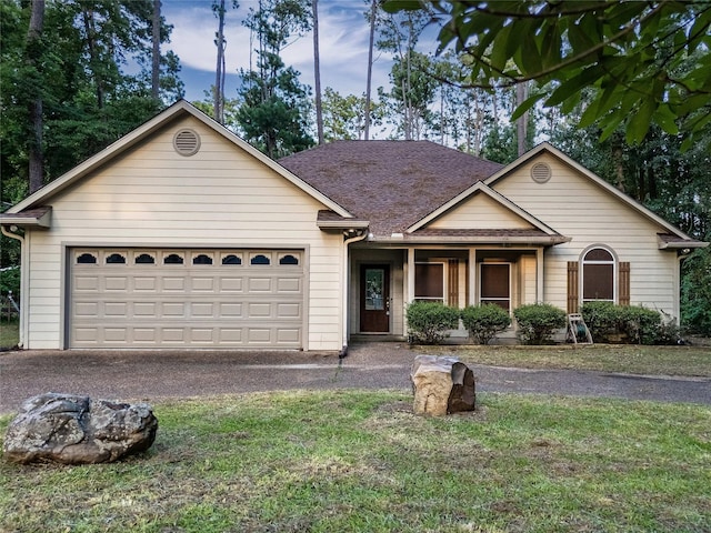 single story home with a garage and a front lawn