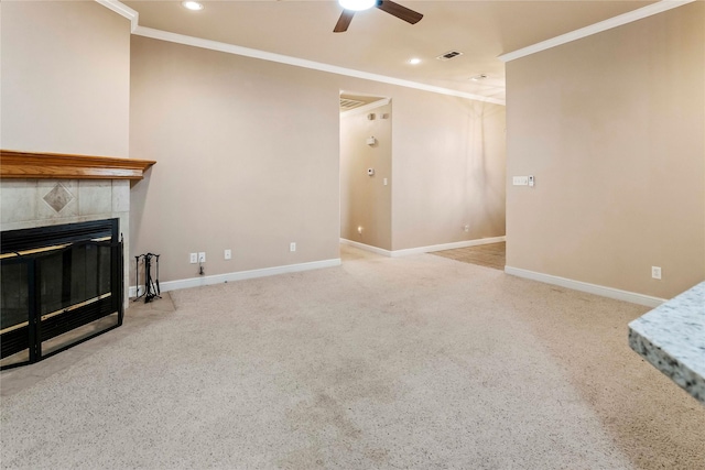 living room with ceiling fan, light carpet, ornamental molding, and a tiled fireplace