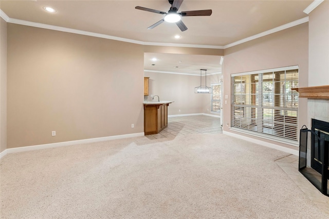 unfurnished living room with ceiling fan, light carpet, ornamental molding, and a fireplace