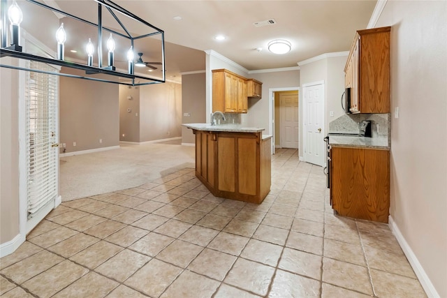 kitchen featuring crown molding, hanging light fixtures, kitchen peninsula, light colored carpet, and stainless steel appliances