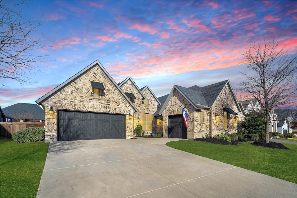 view of front of property featuring a garage and a lawn